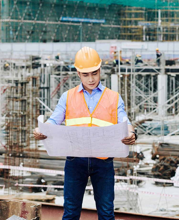 Construction manager reviewing plans on a building site in Bradford